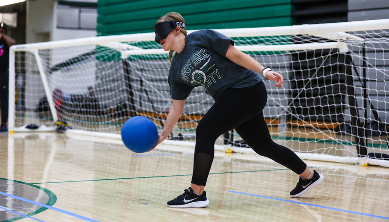 Student rolling ball down the court