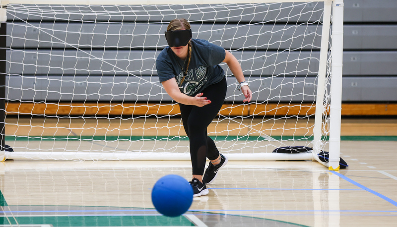 Student rolling ball towards goal