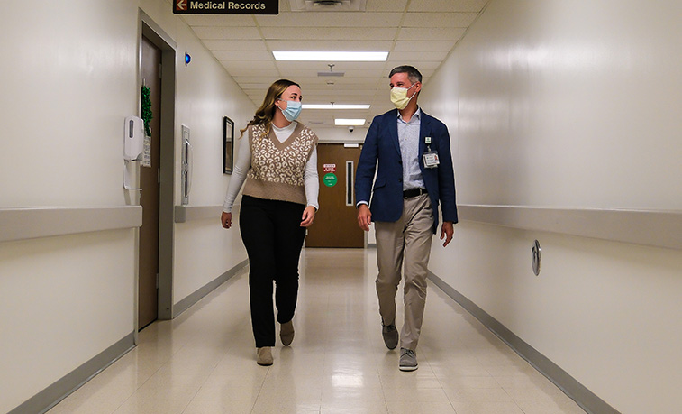 Student walking down a hospital hall with her mentor