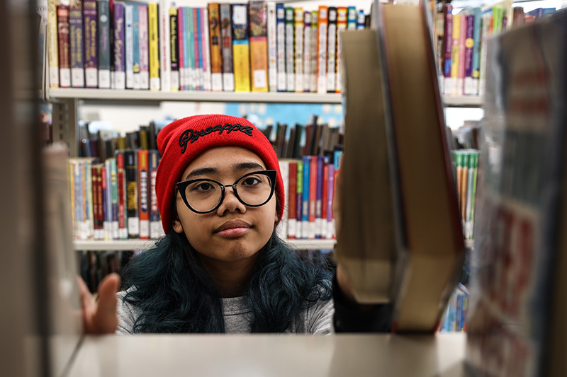 Ellie Manalang putting books away at a library