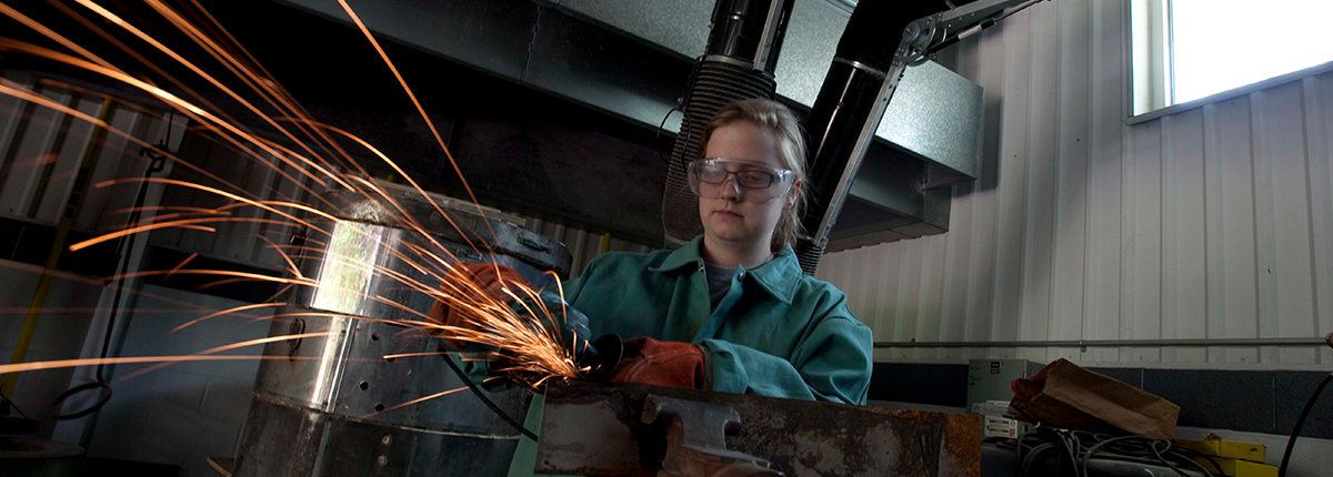 Student using a grinder against a piece of metal