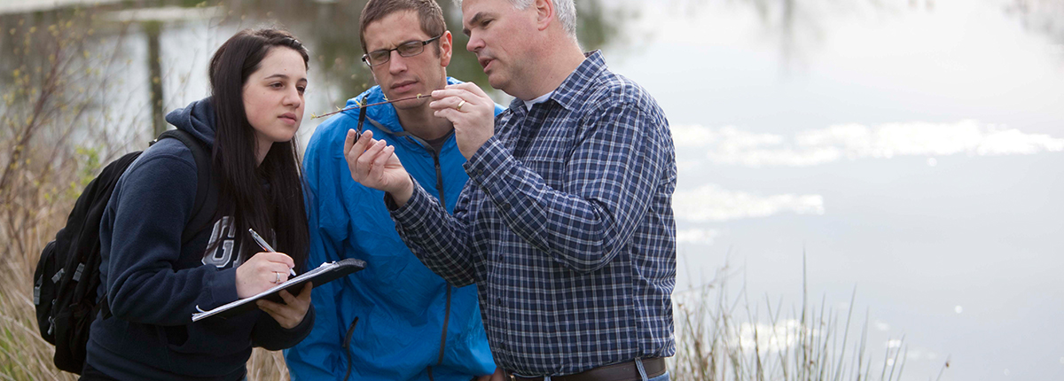 Professor and students examine a specimen