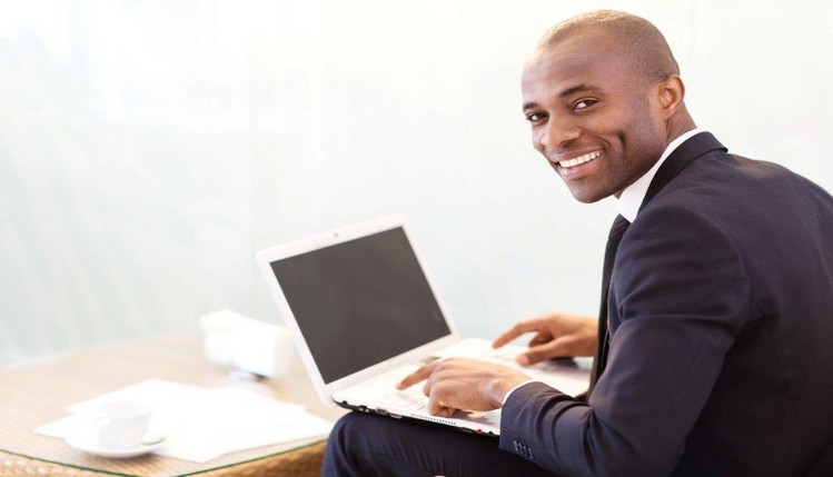 man sitting and typing on laptop