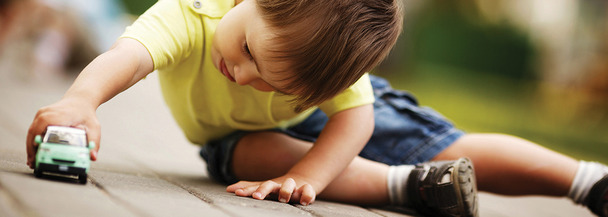 child playing with a toy car