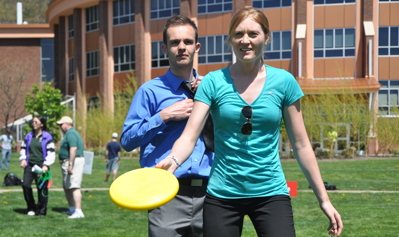 healthy campus dwellers play frisbee