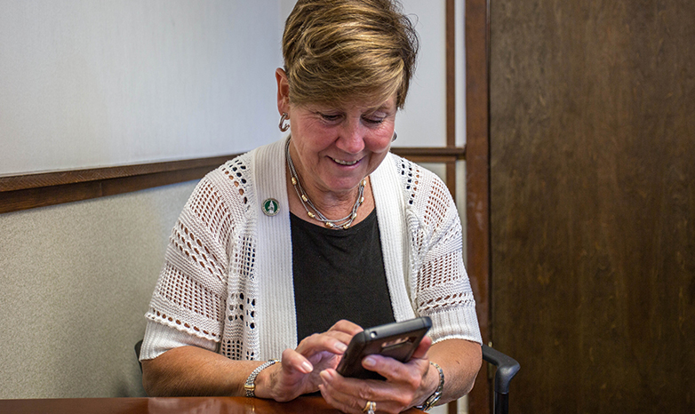 Cheryl Norton logs into twitter account from smart phone