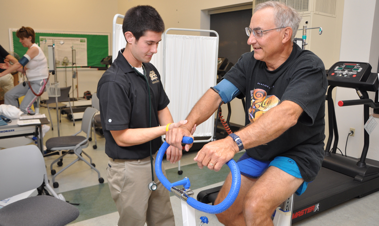fitness therapist working with retired man