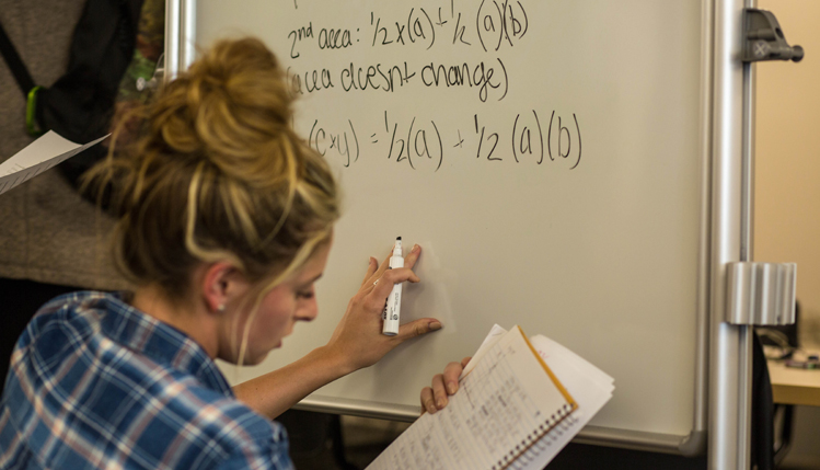 Student writes on dry-erase board