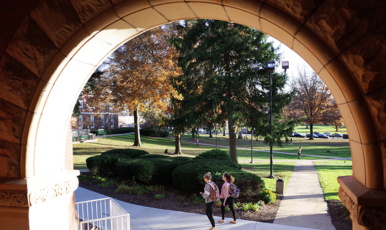 old main arch with students walking past