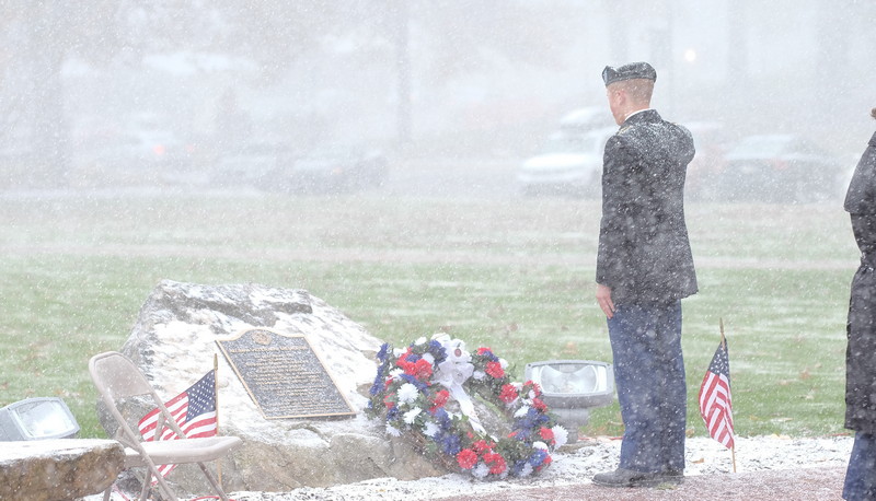 man saluting memorial