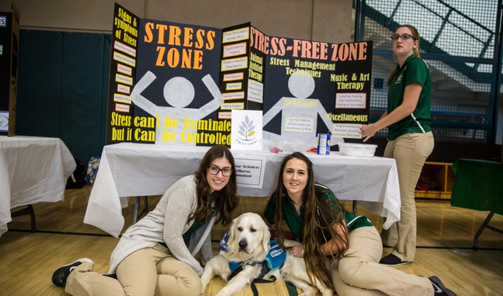 students pose for picture with support dog
