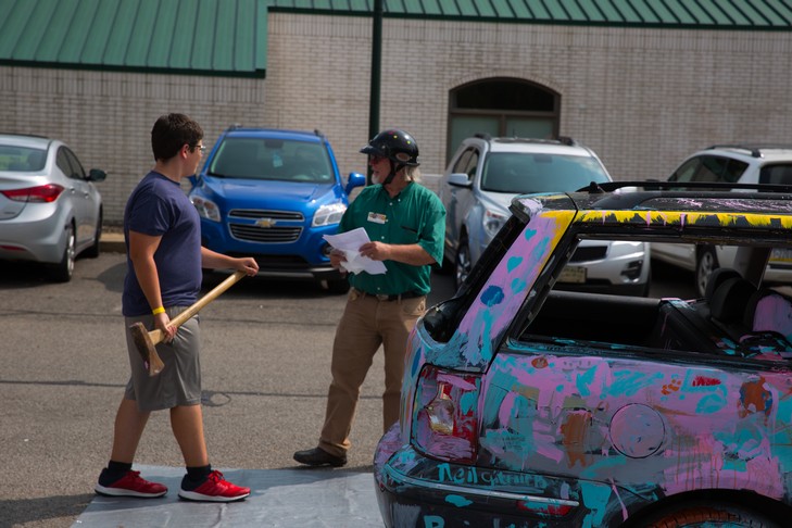 kid gets ready to hit car with axe