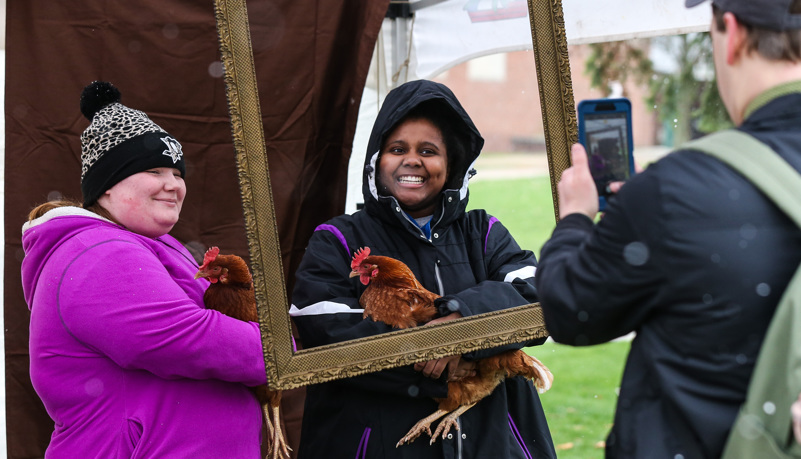 Students get a photo with a chiken