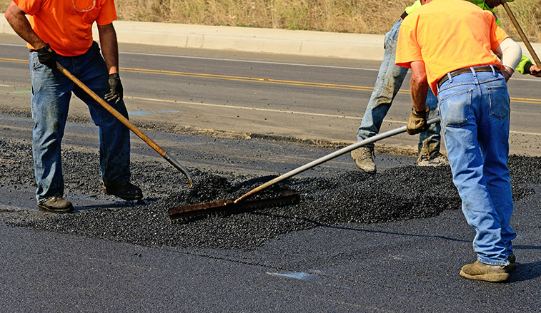 Construction workers laying asphalt