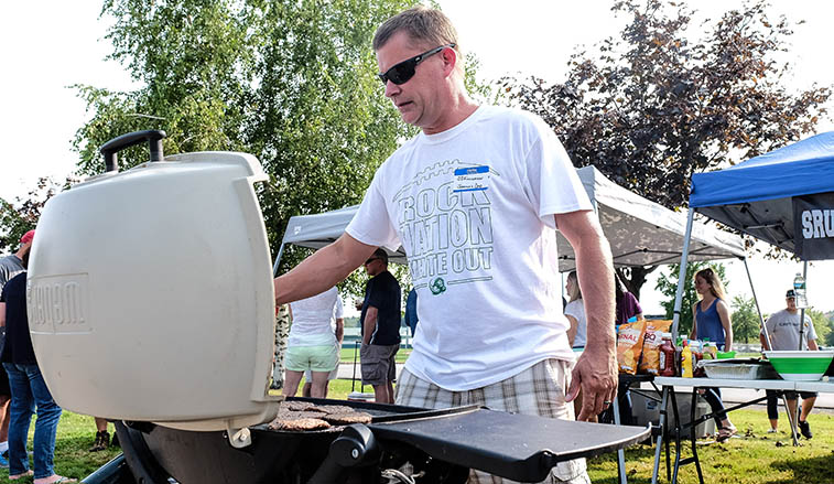 Man grillking burgers at a tailgate