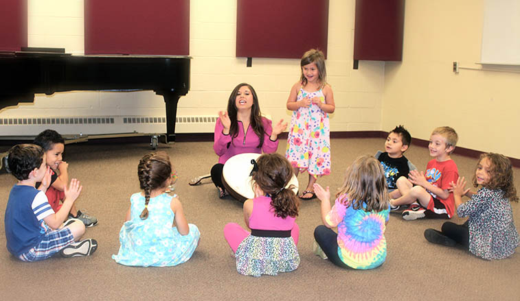 Professor teaching music to pre-school children