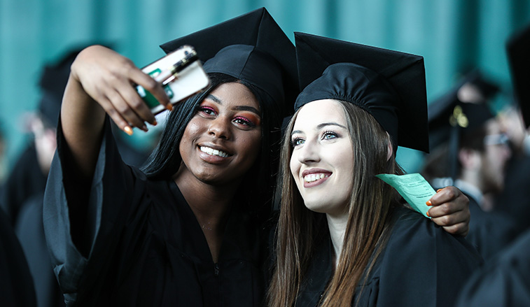 Two students stop for a photo before they graduate